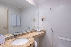 A bathroom with a granite countertop sink, a mirror, two hair dryers mounted on the wall, and a towel rack with two towels. - Great ap With Pool in Resort in Jurere Jbv157 (Florianópolis)