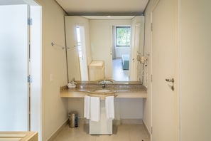 Ett badrum med handfat, spegel och handdukshängare.