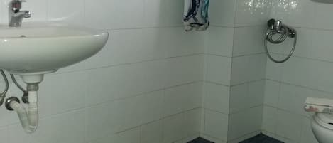 A bathroom with a white sink, a toilet, and a shower curtain.