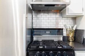 Una cucina con fornello, forno e zoccolo.