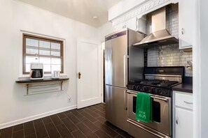 A modern kitchen with stainless steel appliances, a built-in oven, and a window above the countertop. - Clover Cottage - 1 mile to ND - Cozy Getaway (South Bend)