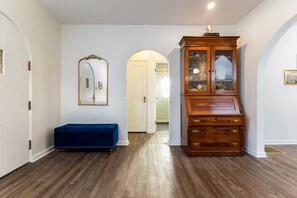 A hallway with a blue bench, a wooden cabinet, and a mirror on the wall. - Clover Cottage - 1 mile to ND - Cozy Getaway (South Bend)