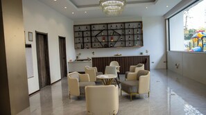 A modern lobby with a chandelier, seating area, and a wine display. - Luxury Two bedroom Apartment  in  kileleshwa (Nairobi)