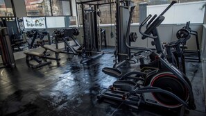 Ein Fitnessstudio mit verschiedenen Trainingsgeräten, darunter Laufbänder und Kraftgeräte.