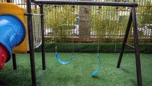 A playground with a swing set and a slide. - Luxury Two bedroom Apartment  in  kileleshwa (Nairobi)