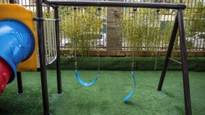 A playground with a swing set and a slide. - Luxury Two bedroom Apartment  in  kileleshwa (Nairobi)