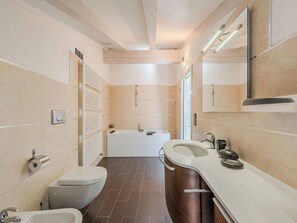 Ein modernes Badezimmer mit Badewanne, Toilette und Waschbecken.