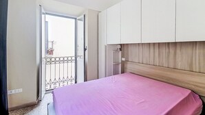 A bedroom with a bed, a wardrobe, and a balcony door. - Nice apartment for 6 guests with A/C and TV (Caramanico Terme)