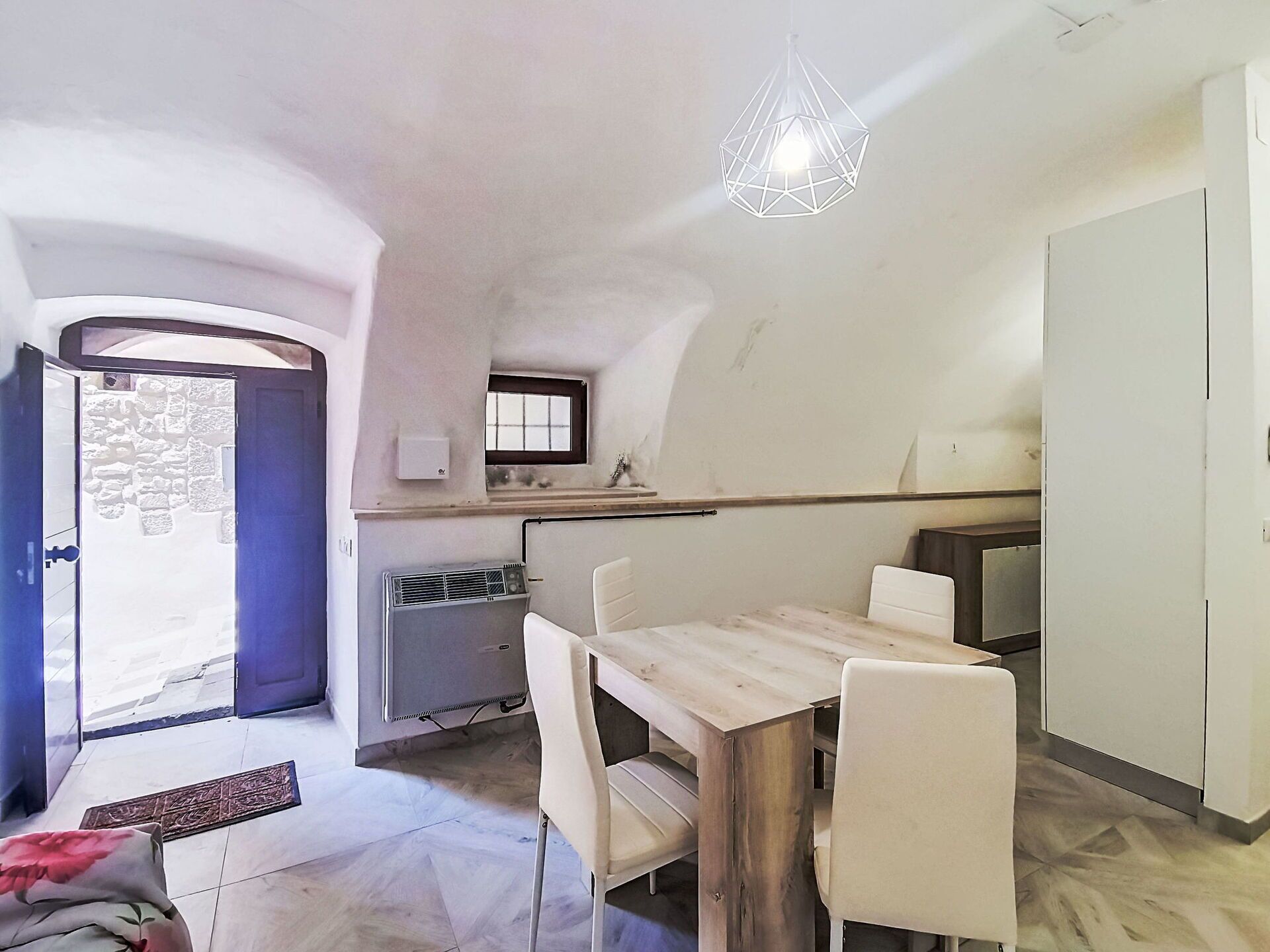 Uma cozinha compacta com área de jantar, forno embutido e janela sobre a pia.