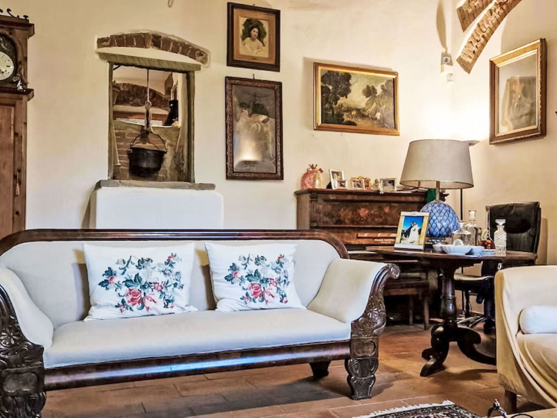 A traditional living room with a sofa, a table, and a lamp.
