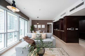 Ein modernes Wohnzimmer mit einer Couch, einem Couchtisch und einem großen Fenster mit Blick auf die Stadt.