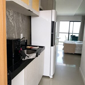 Eine moderne Küche mit eingebauter Mikrowelle, einer Spüle und einem Kühlschrank.