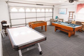 A recreational room with a foosball table, a pool table, and a table tennis table. - 12 Min to Disney! Pool, Hot Tub & Game Room (Kissimmee)