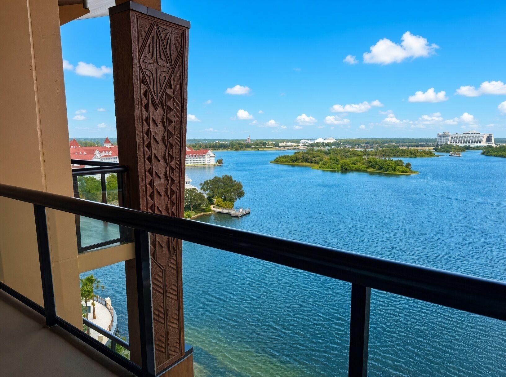A view from a balcony overlooking a river with a distant island and buildings.