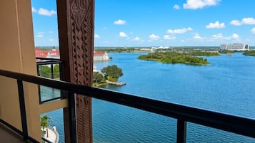 A view from a balcony overlooking a river with a distant island and buildings.