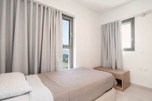 A bedroom with a bed, bedside tables, and curtains. - Sofia`s Estates : Villa Savvas (Adults Only) (Lagoudi Zia)