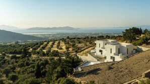 A modern two-story building with a flat roof, surrounded by olive groves and a hilly landscape. - Sofia`s Estates : Villa Savvas (Adults Only) (Lagoudi Zia)