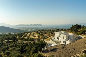A modern two-story building with a flat roof, surrounded by olive groves and a hilly landscape. - Sofia`s Estates : Villa Savvas (Adults Only) (Lagoudi Zia)
