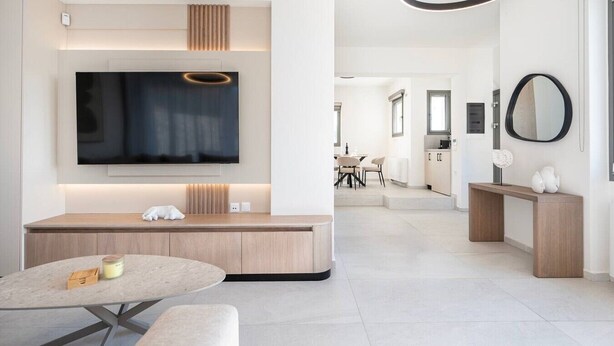 A modern living room with a flat-screen TV, a seating area, and a dining space. - Sofia`s Estates : Villa Savvas (Adults Only) (Lagoudi Zia)