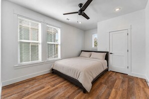 A bedroom with a bed, a ceiling fan, and a door. - 3-bedroom 2.5-bathroom house walking distance from the campus and Dixon with AC (Fayetteville)