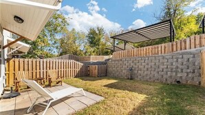 A backyard with a patio, a wooden fence, and a brick wall. - 3-bedroom 2.5-bathroom house walking distance from the campus and Dixon with AC (Fayetteville)