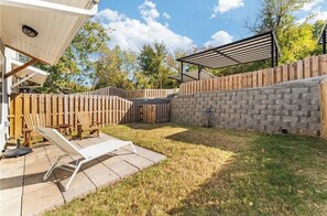 A backyard with a patio, a wooden fence, and a brick wall. - 3-bedroom 2.5-bathroom house walking distance from the campus and Dixon with AC (Fayetteville)