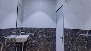 Un baño con ducha, lavamanos y puerta.