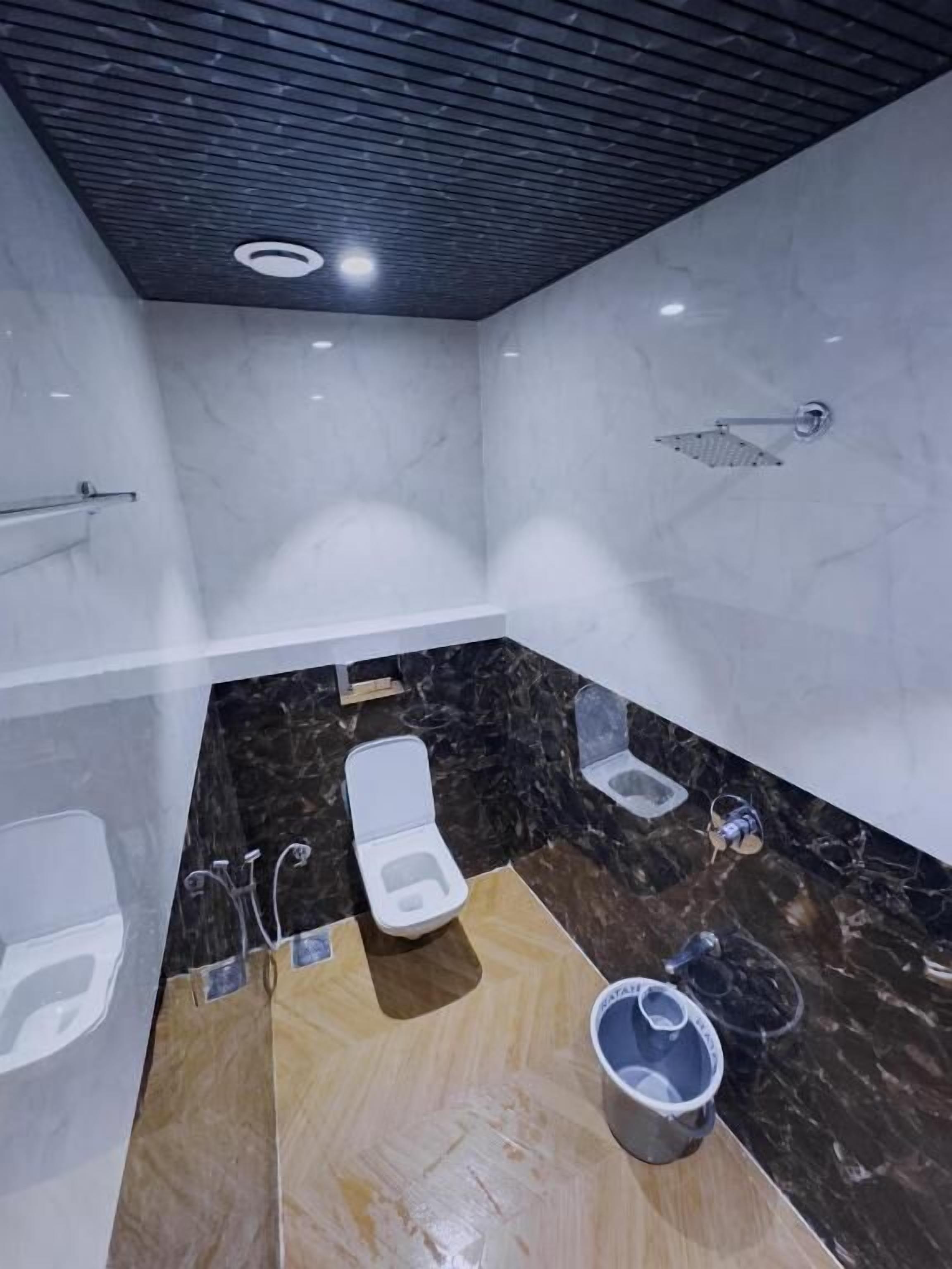 Een badkamer met toilet, bidet en douche.