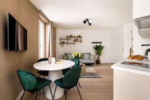 Eine moderne Küche mit Essbereich, einem Wand-Fernseher und einem Deckenventilator.