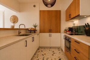 Eine moderne Küche mit Spüle, Holzschränken, Herd und Arbeitsplatte.
