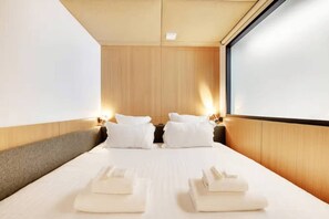 A hotel room with a large bed, two bedside tables, and a wooden headboard. - Lavie Maison : Prestige Near Place des Vosges (Paris)