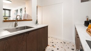 Eine moderne Küche mit integriertem Spülbecken, Holzschränken und einem Terrazzo-Boden.