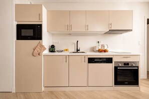 A modern kitchen with a microwave, Bosch dishwasher, and oven. - Lavie Maison : Cozy Apartment in the city (Paris)