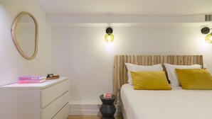 Un dormitorio con cama, mesita de noche y espejo.