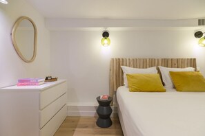 Ein Schlafzimmer mit Bett, Nachttisch und Spiegel.