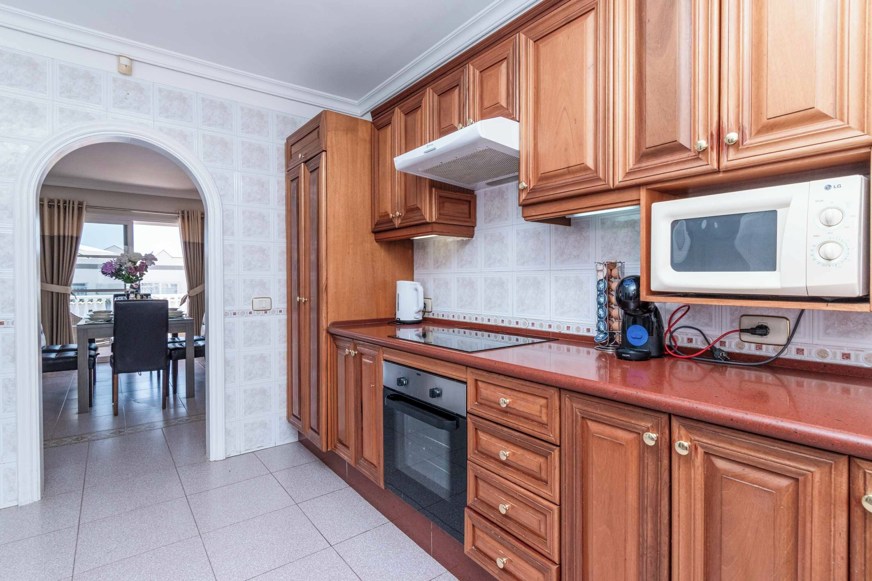 A kitchen with wooden cabinets, a microwave, and a coffee maker.