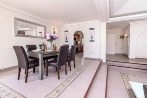 A dining area with a rectangular table, six chairs, and a vase of flowers. - Tiffany 16 - Three Bedroom Villa, Sleeps 6 (Callao Salvaje)