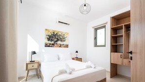 Ein Schlafzimmer mit einem Bett, Nachttischen, einer Hängelampe, einem Fenster und einem Holzschrank.