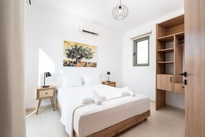 Ein Schlafzimmer mit einem Bett, Nachttischen, einer Hängelampe, einem Fenster und einem Holzschrank.