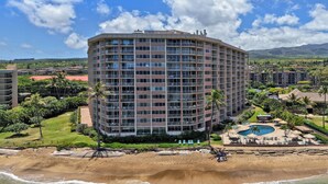 A multi-story hotel with a pool, beach access, and a view of the surrounding landscape. - Sweet Studio with AC (Lahaina)