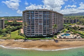 Ein mehrstöckiges Hotel mit Pool, Strandzugang und Blick auf die umliegende Landschaft.