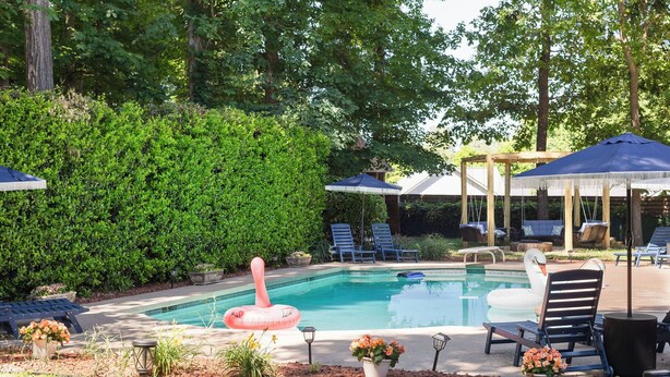 A swimming pool with lounge chairs and umbrellas, surrounded by greenery. - 5 Kings, 2 Q pullouts, 5 bedroom, 4 bath, Firepit, Pool, Jacuzi in Knoxville (Knoxville)