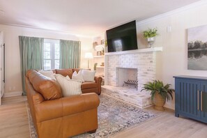 A living room with a brown leather sofa, a fireplace, and a television mounted above it. - 5 Kings, 2 Q pullouts, 5 bedroom, 4 bath, Firepit, Pool, Jacuzi in Knoxville (Knoxville)
