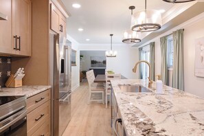A modern kitchen with a marble countertop, stainless steel appliances, and a central island with a sink. - 5 Kings, 2 Q pullouts, 5 bedroom, 4 bath, Firepit, Pool, Jacuzi in Knoxville (Knoxville)