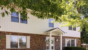 A building with a brick facade, a covered entrance, and a well-maintained lawn. - 5 Kings, 2 Q pullouts, 5 bedroom, 4 bath, Firepit, Pool, Jacuzi in Knoxville (Knoxville)