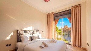 A hotel room with a large bed, a view of the outdoors, and a balcony.