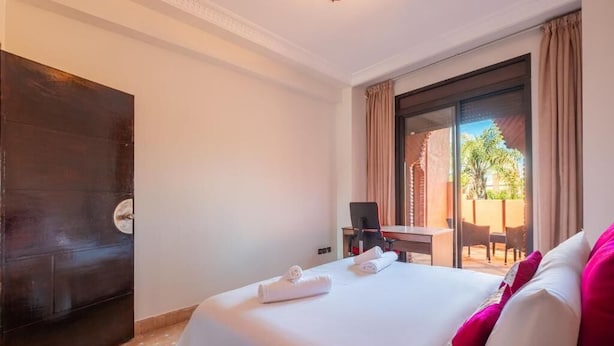 A hotel room with a bed, a desk, and a view of the outside. - 3 BDRM Villa Garden & Pool Front (Marrakech)