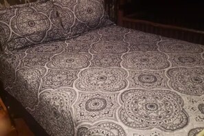 A bed with a patterned bedspread.