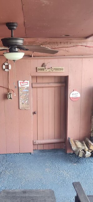 Une porte en bois avec une pancarte indiquant « En train de pêcher » et une autre qui dit « J’aimerais bien être en train de pêcher ».