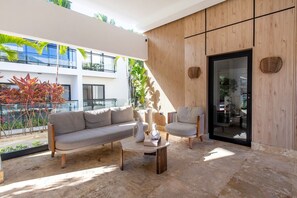 A modern outdoor seating area with a sofa, chairs, and a coffee table. - First-floor apartment 7 minutes from the beach (Punta Cana)